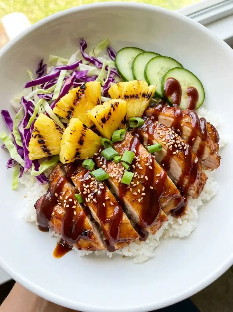 Hawaiian BBQ chicken rice bowl with grilled pineapple, cabbage, cucumber, and green onions