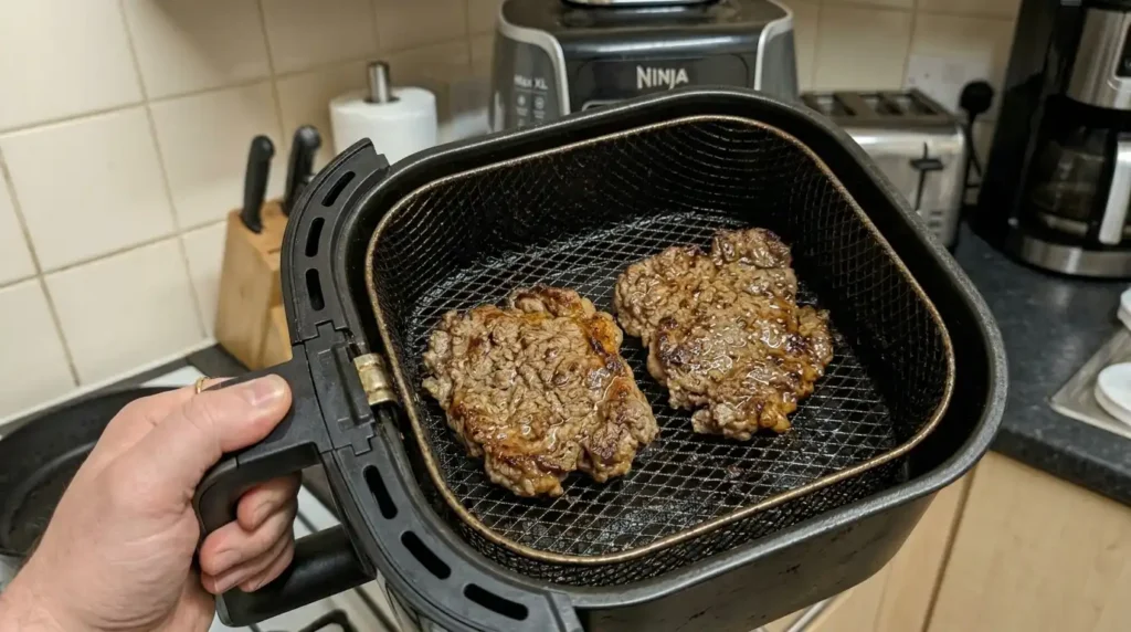 Cooking cube steaks in air fryer basket — golden brown crust